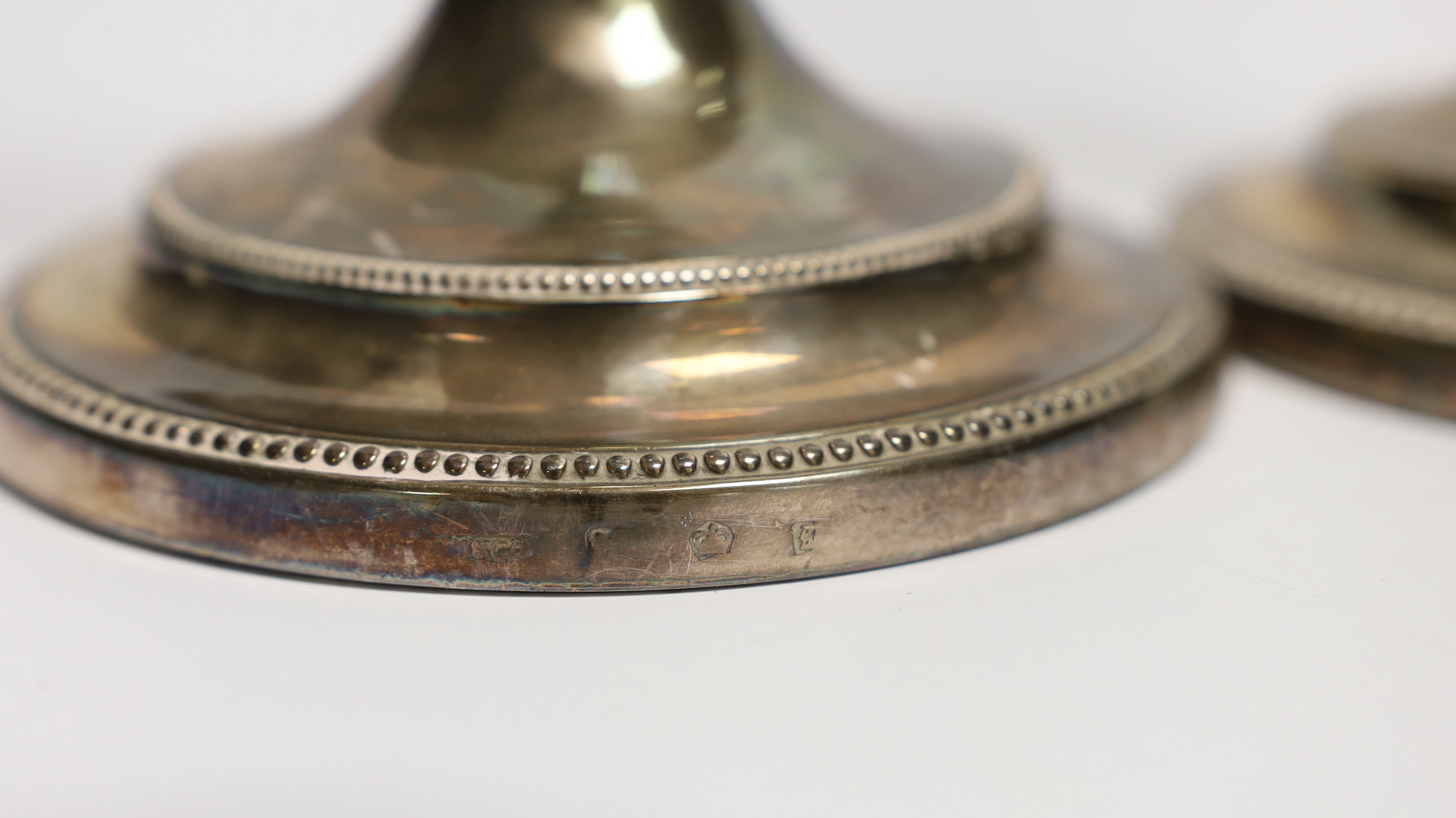 A pair of George III silver candlesticks, with waisted fluted stems, John Winter & Co, Sheffield, date letter rubbed, circa 1780, height 30cm, weighted, lacking one sconce.